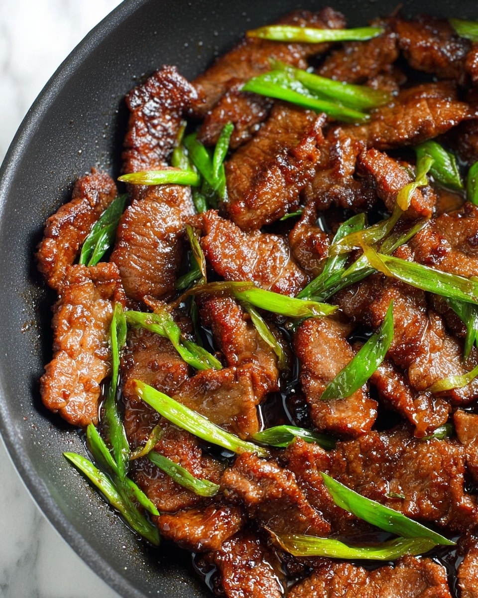 A close-up view of a black pan filled with thin strips of cooked meat, browned and glazed with a shiny dark sauce, giving them a slightly sticky texture. Bright green pieces of cooked green onions are spread evenly among the meat, adding a fresh contrast to the rich brown tones. The meat pieces vary in size and have a slightly crispy texture on the edges. The pan sits on a white marbled surface, with soft natural light highlighting the glossy sauce and the vibrant green of the onions. Photo taken with an iphone --ar 4:5 --v 7