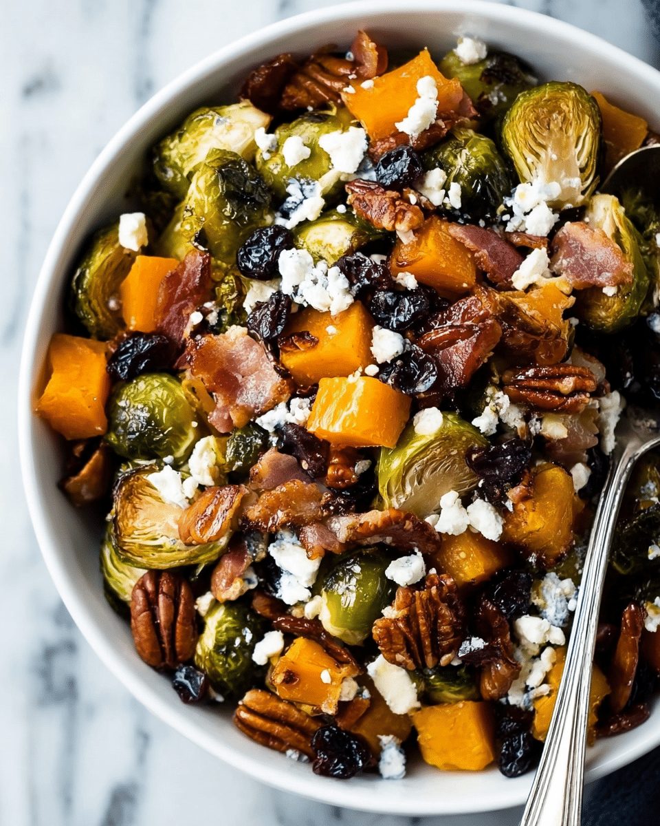 The image shows a close-up of a white bowl filled with a colorful mix of roasted Brussels sprouts, browned bacon pieces, orange chunks of butternut squash, dark dried cranberries, and whole pecan nuts. Small crumbles of white cheese are scattered on top, adding contrast to the warm tones of the roasted vegetables and nuts. The textures range from the crispy bacon and pecans to the soft, juicy squash and slightly charred Brussels sprouts. A silver spoon rests on the right edge of the bowl, all set against a white marbled background. photo taken with an iphone --ar 4:5 --v 7