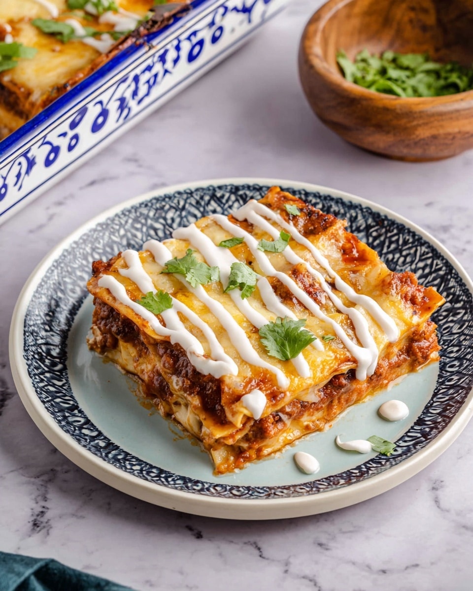 A square piece of lasagna sits on a white plate with a light blue pattern on the rim. It has three visible layers: a bottom pasta layer, a thick middle layer of meat and sauce, and a top layer covered in melted golden brown cheese. White creamy sauce is drizzled in lines across the top, and small green cilantro leaves are scattered on the cheese. Part of a white baking dish with blue designs is in the upper left corner, and a wooden bowl with green herbs is in the upper right corner, all placed on a white marbled surface. Photo taken with an iphone --ar 4:5 --v 7