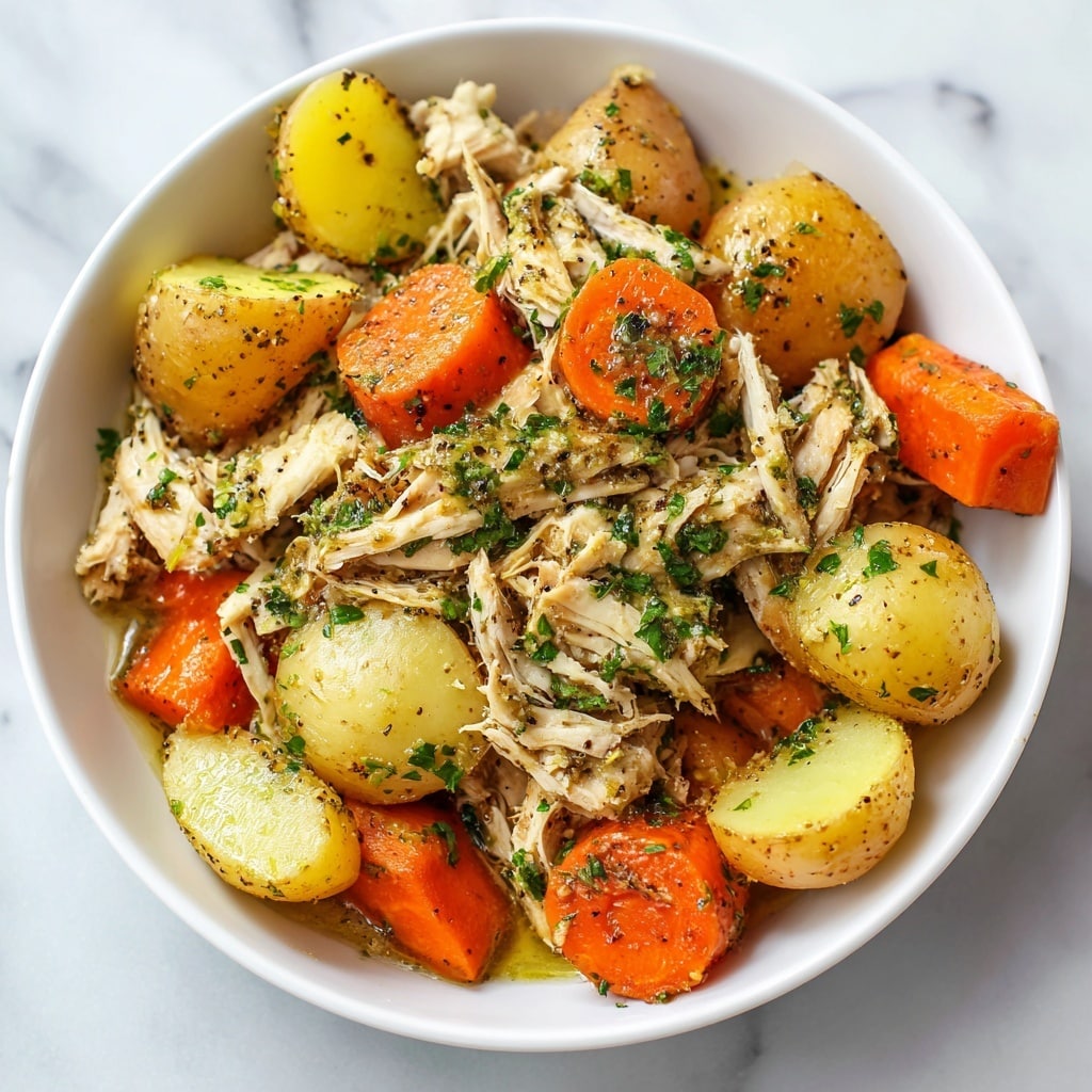 The image shows a close-up of a dish with shredded chicken mixed with small yellow and red potatoes and large chunks of carrots. The chicken is seasoned with green herbs and black pepper, giving it a textured look. The carrots are bright orange and cut into thick pieces, surrounding the chicken and potatoes. The dish fills the white bowl fully, with the food looking moist and well-cooked. The background surface is a white marbled texture. photo taken with an iphone --ar 4:5 --v 7