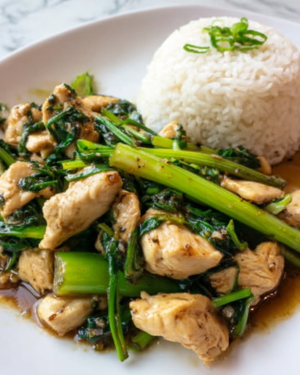 A close-up image of a dish showing a mound of white rice on the left side and a stir-fry mix on the right. The stir-fry contains green vegetables that look like chopped green onions or garlic chives, bright and shiny with a slightly oily texture, and small pieces of cooked white chicken in irregular chunks, coated in a glossy sauce. The background is a white marbled surface. The colors are mainly white, green, and light brown from the sauce. Photo taken with an iphone --ar 4:5 --v 7