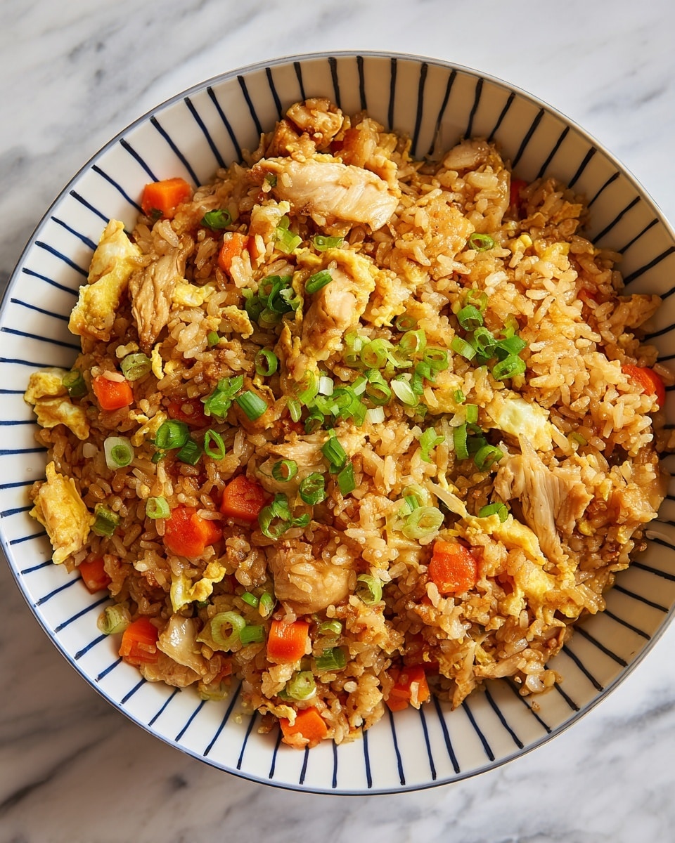 A close-up of a bowl filled with fried rice, showing multiple layers including golden-brown cooked rice grains, small diced orange carrots, light brown cooked chicken pieces, scrambled yellow eggs, and small green onion slices mixed throughout. The bowl is white with thin vertical blue stripes and filled to the top, sitting on a white marbled surface. The texture of the rice looks slightly crispy, and the ingredients are well combined but still distinct. photo taken with an iphone --ar 4:5 --v 7